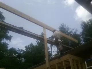 Carpenter setting a ridge beam over a new addition frame — Ice Dam Removal by Roofing Brothers in Green Village