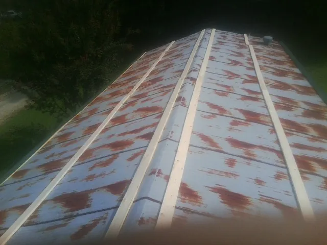 Rusted metal roof panels with new wood purlins before replacement — Storm Damage Roof Repair in Green Village by Roofing Brothers
