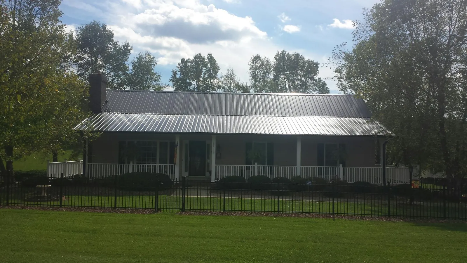 Gray metal roof on a brick ranch with a full width front porch — Gutter Guard Installation work by our crew in Green Village