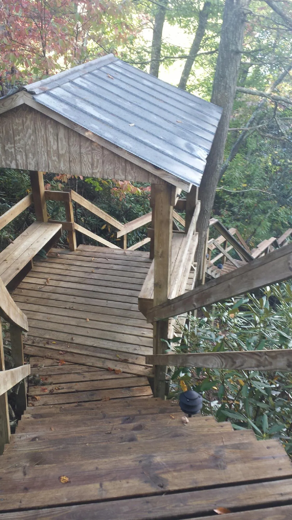 Metal roofed shelter over wooden steps on a wooded walkway — Skylight Repair & Installation work by our crew in Green Village