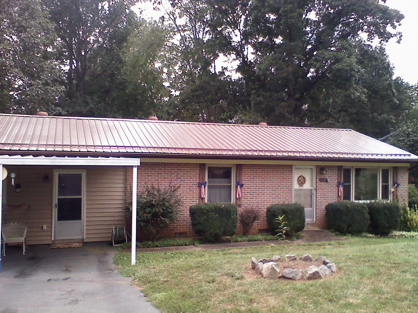 Bronze metal roof and carport on a brick ranch home — Roof Repair work by our crew in Green Village